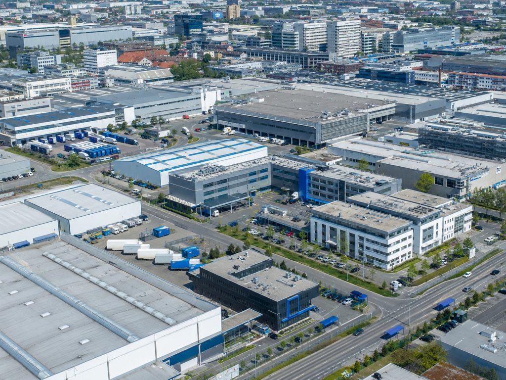 Luftaufnahme eines Ludwigsburger Industriegebiets mit Produktions- und Fertigungshallen, Lkw-Höfen und modernen Bürobauten, urban, Tageslicht, kaum Natur.