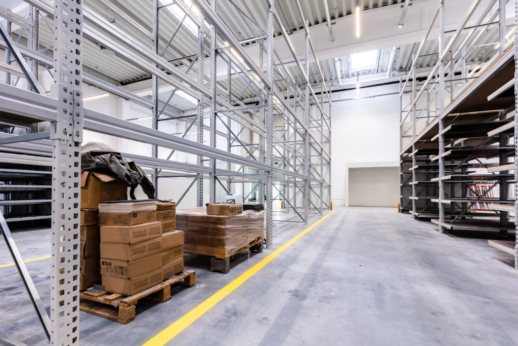 Leere Logistikimmobilien mit Hochregalen und heller Lagerhalle